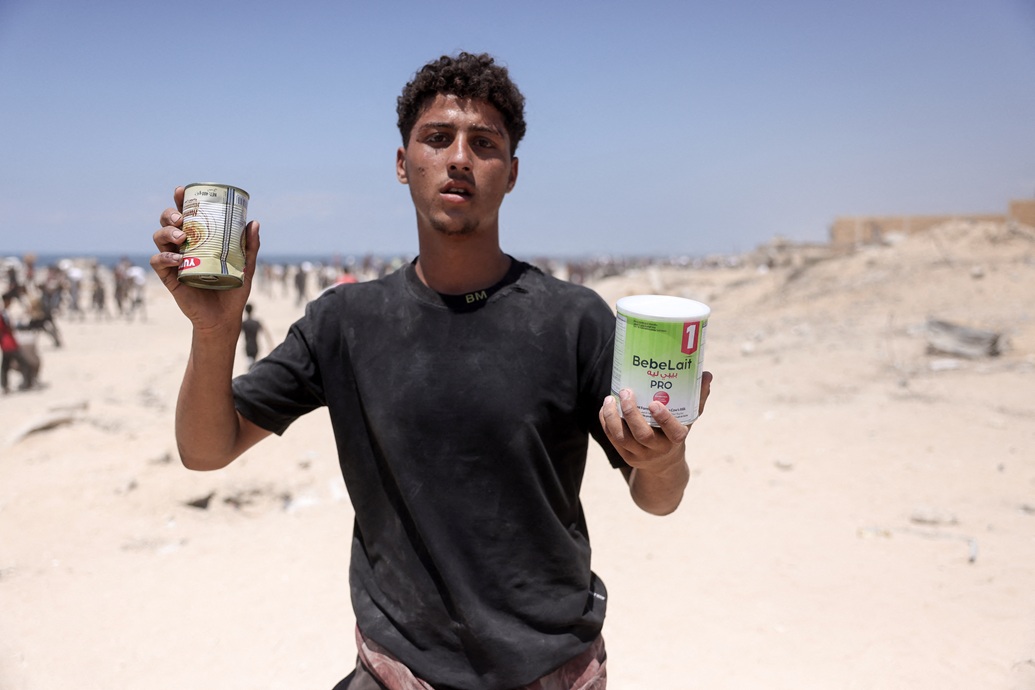شاب فلسطيني عائد من منطقة دخلت فيها شاحنات المساعدات إلى غزة عبر معبر زيكيم، في جباليا شمال قطاع غزة (أ ف ب)