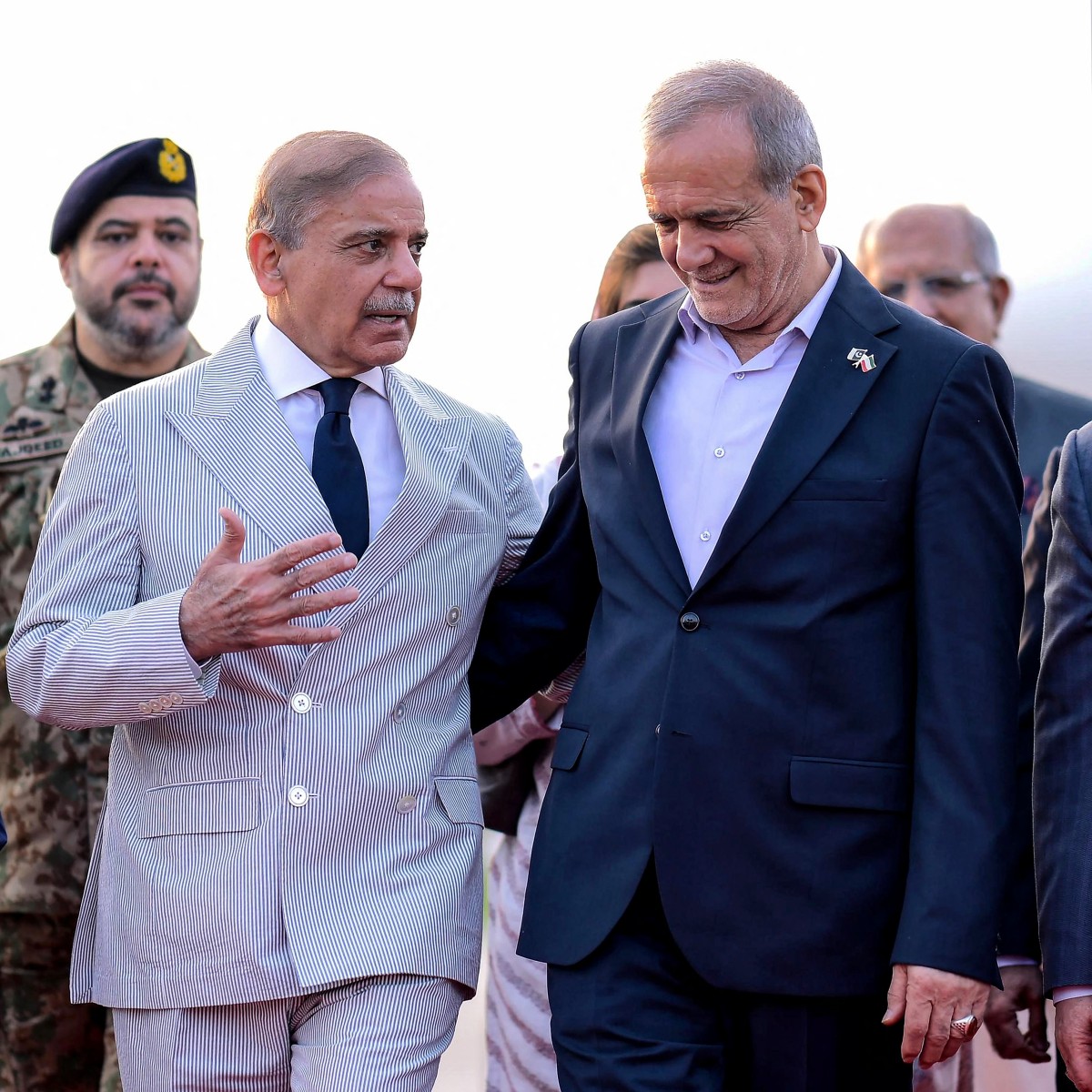 شريف مستقبلاً بزشكيان في مطار إسلام آباد. (أ ف ب)