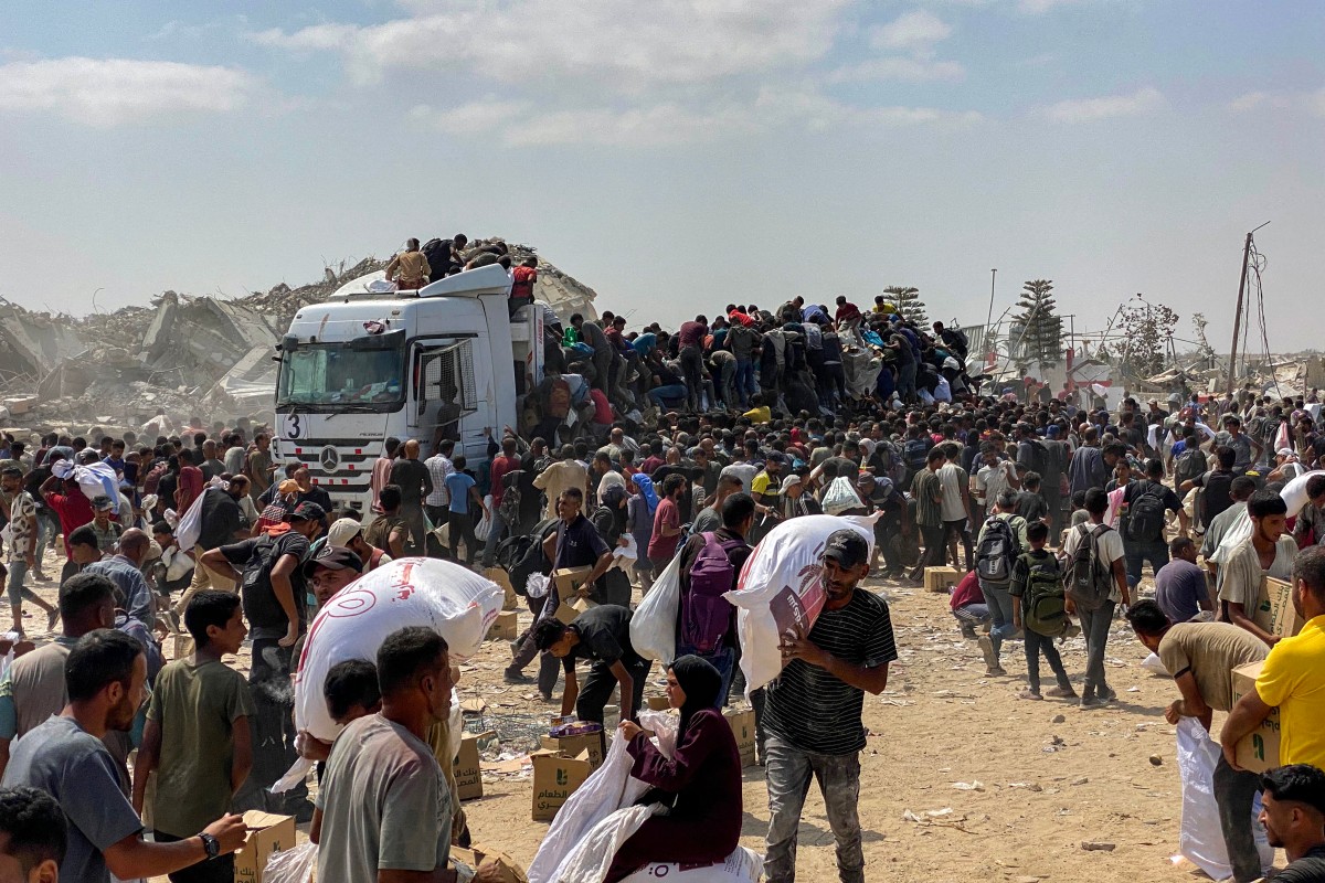 فلسطينيون يحملون مواد غذائية (أ ف ب)