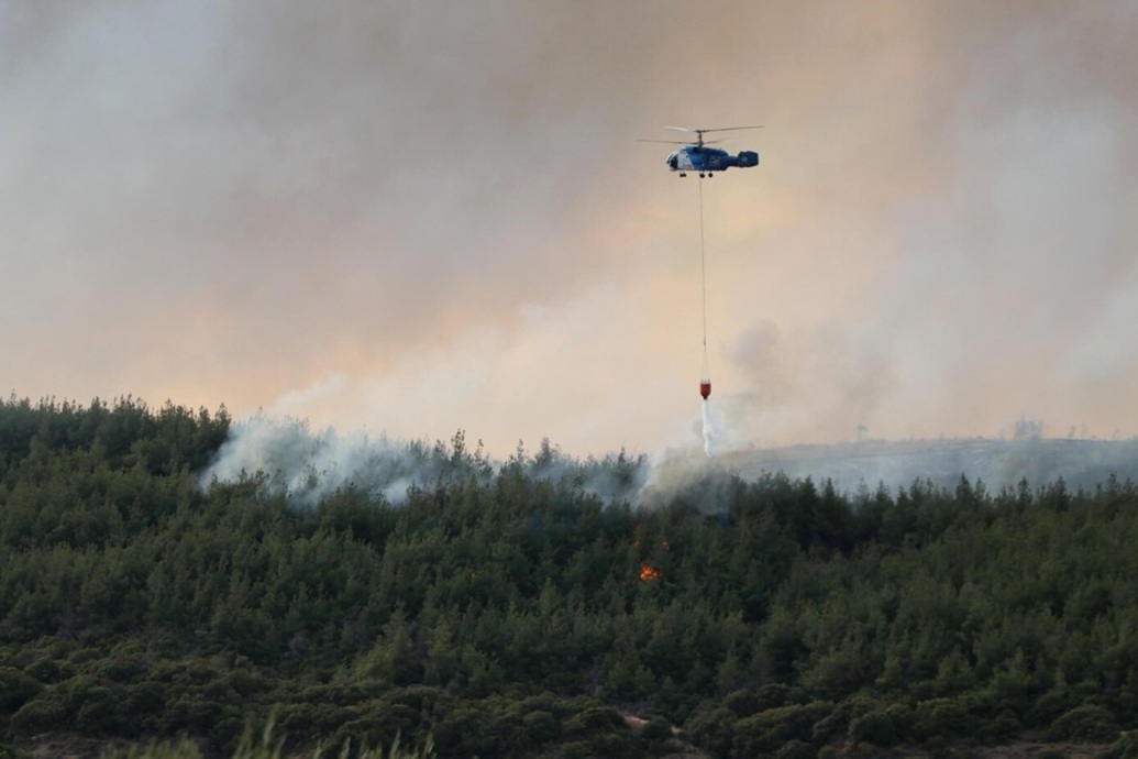 طائرة إطفاء ترش المياه فوق منطقة محترقة بعد اندلاع حريق هائل في منطقة غيليبولو (أ ف ب)