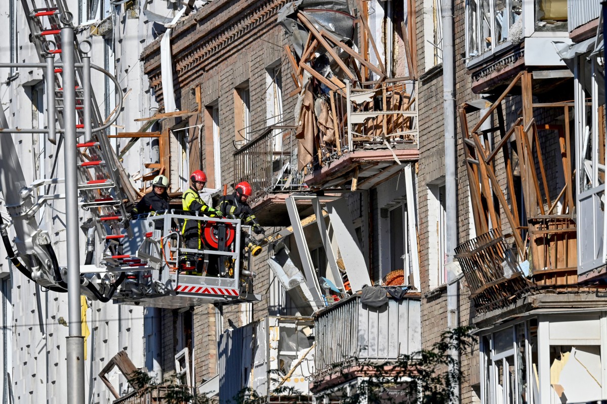 إزالة الأنقاض في مبنى سكني في منطقة متضررة بالعاصمة الأوكرانية بعد هجمات روسية (أ ف ب).