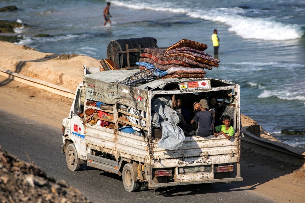 فلسطينيون نازحون جنوباً يركبون شاحنة محملة بأمتعتهم في وسط قطاع غزة. (أ ف ب)
