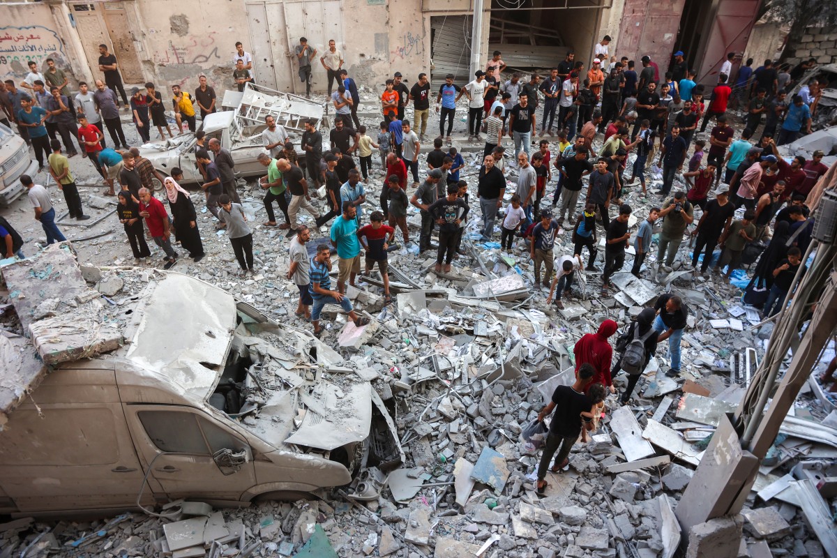 يتجمع فلسطينيون للبحث عن ناجين في موقع غارة إسرائيلية استهدفت عدة مبان في حي الرمال في مدينة غزة (أ ف ب).