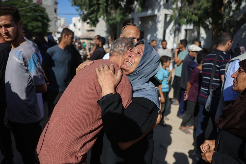 فلسطينيون خارج مستشفى الشفاء حيث تم نقل ضحايا الغارات الإسرائيلية على مدينة غزة (أ ف ب)