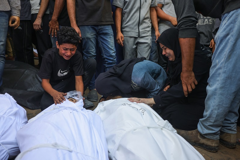 فلسطينيون ينعون جثث أقاربهم المغطاة بالأكفان قتلوا في غارات إسرائيلية على مدينة غزة، (أ ف ب).