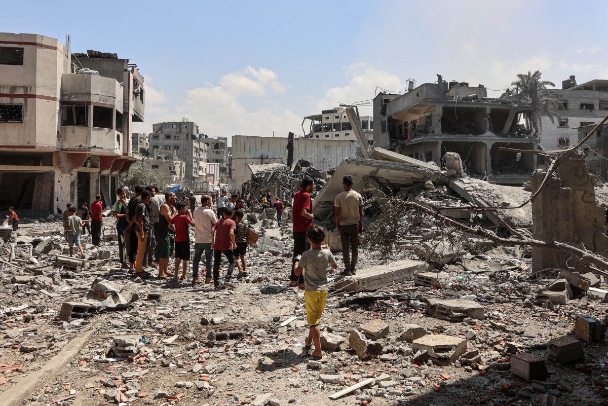   فلسطينيون يتفقدون الأنقاض بعد أن دمرت غارة إسرائيلية مسجد التوحيد والسنة في حي الدرج في مدينة غزة (أ ف ب)