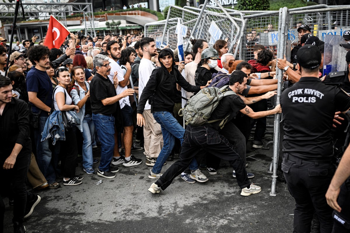 يحاول المتظاهرون إزالة الأسوار التي وضعتها الشرطة خارج مقر حزب المعارضة الرئيسي في تركيا (أ ف ب)