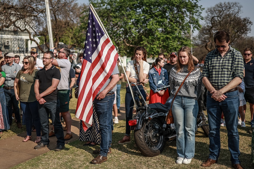 المعزون يقفون خلال مراسم وضع إكليل من الزهور خارج السفارة الأميركية في بريتوريا عقب مقتل كيرك (أ ف ب)
