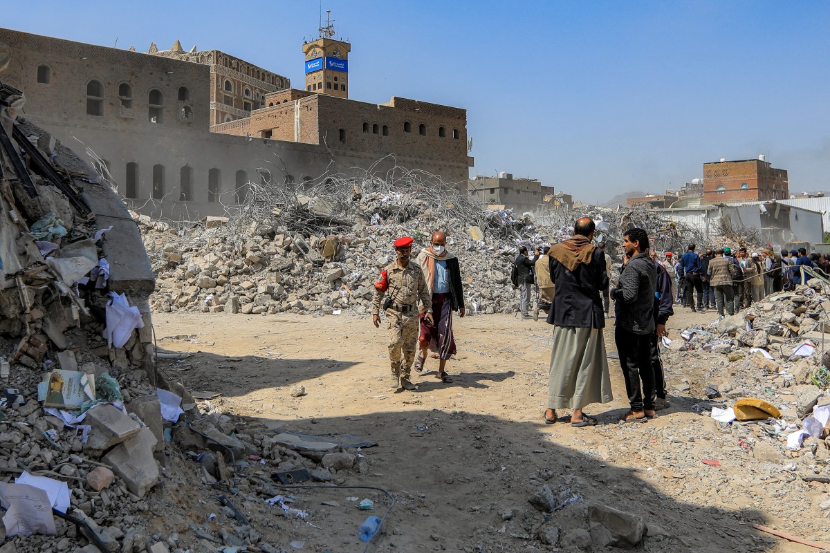 أشخاص يتفقدون أنقاض مبنى بعد أيام من هدمه في غارة إسرائيلية على العاصمة اليمنية صنعاء  (أ ف ب)
