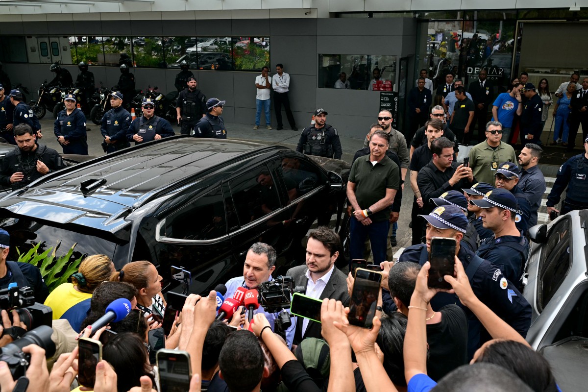 بولسونارو محاطاً بالصحافيين. (أ ف ب)