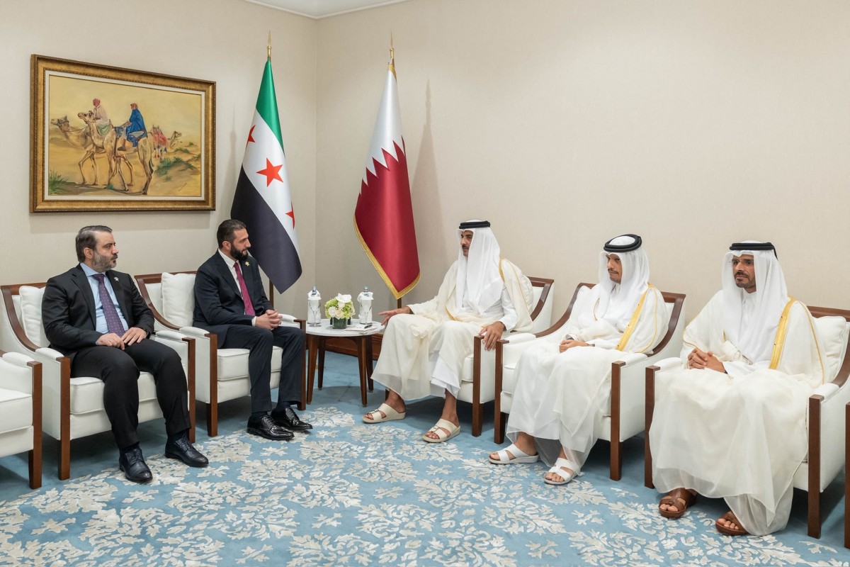 أمير قطر الشيخ تميم بن حمد آل ثاني وهو يلتقي بالرئيس السوري أحمد الشرع في الدوحة (أ ف ب)