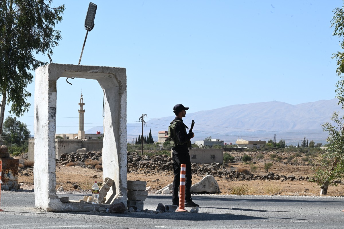 عنصر من الأمن السوري يحرس قاعدة عسكرية سابقة بالقرب من مدينة القنيطرة. (أ ف ب)