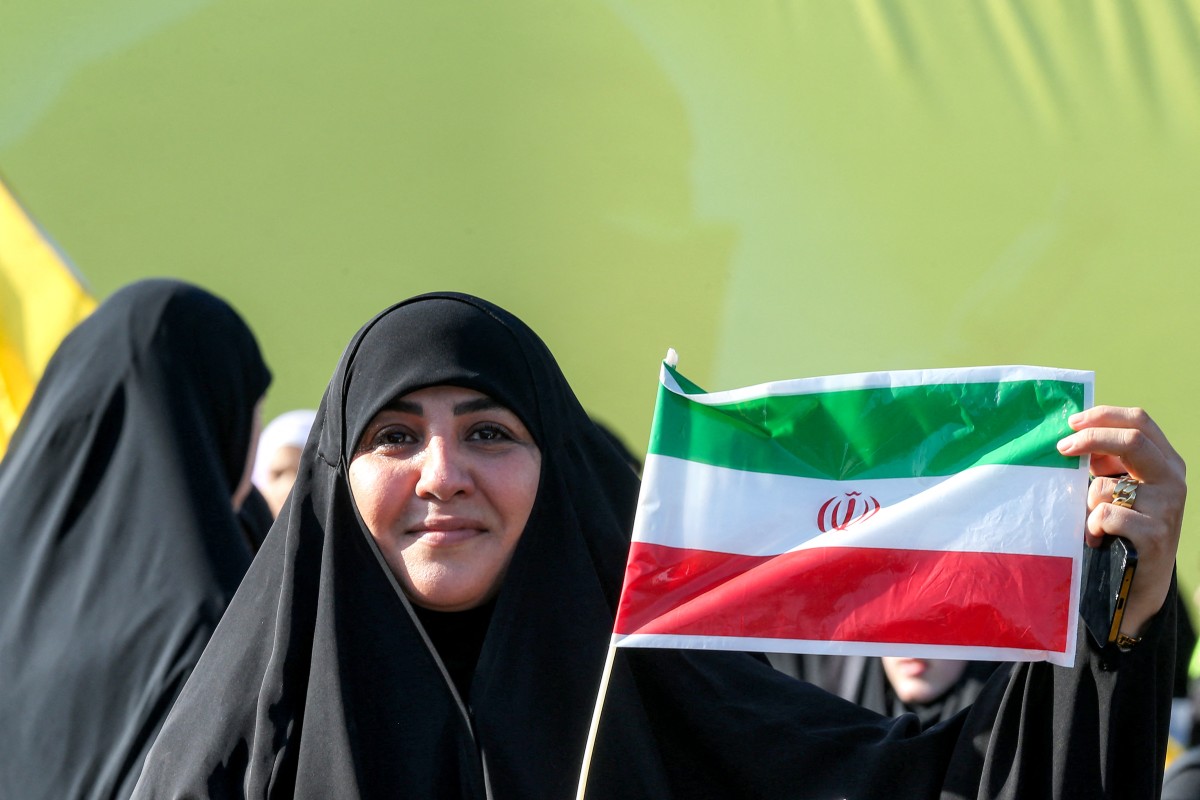 سيدة إيرنية ترفع علم بلدها (أ ف ب).