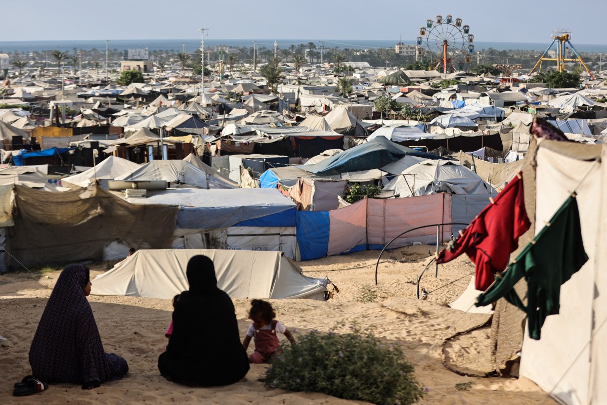 سيدتان تجلسان أمام الخيام في قطاع غزة (أ ف ب).
