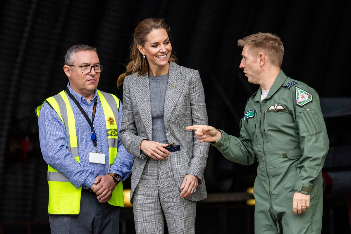كيت ميدلتون خلال زيارتها لقاعدة كونينغسبي بالبدلة الرمادية (أ.ف.ب)