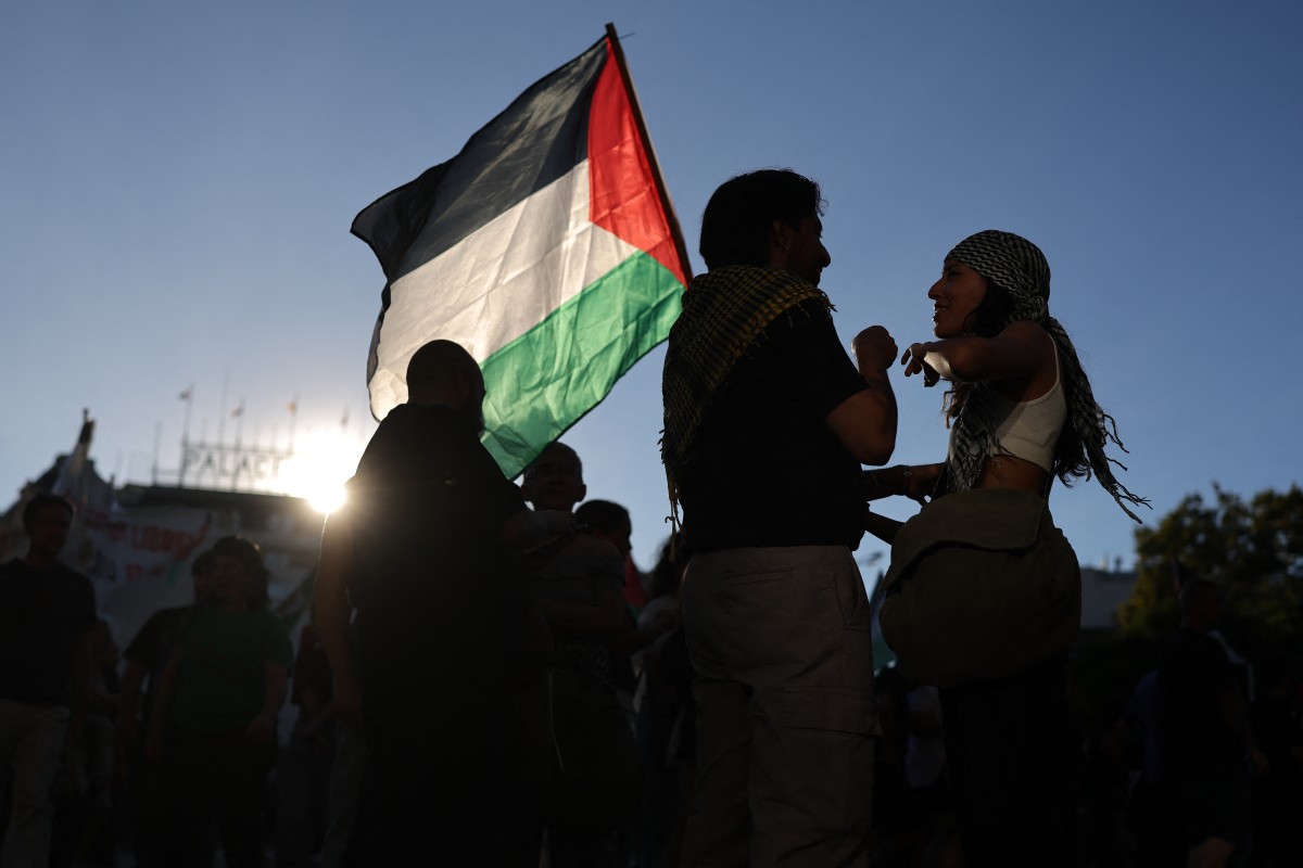 شاب يحمل علماً فلسطينياً خلال مظاهرة تضامن مع الفلسطينيين في قطاع غزة، في مدريد. (أ ف ب)
