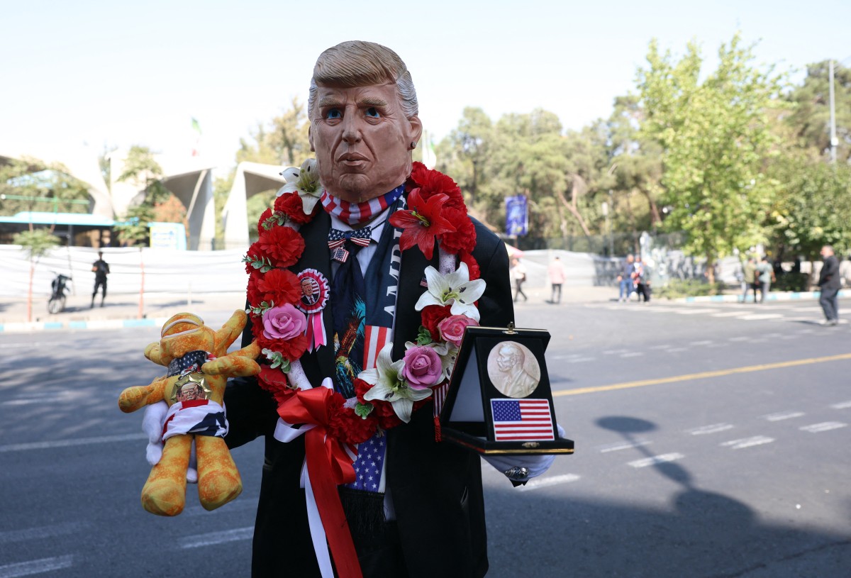 رجل يرتدي قناعاً على هيئة الرئيس الأميركي دونالد ترامب خلال تظاهرة في طهران. (أ ف ب)