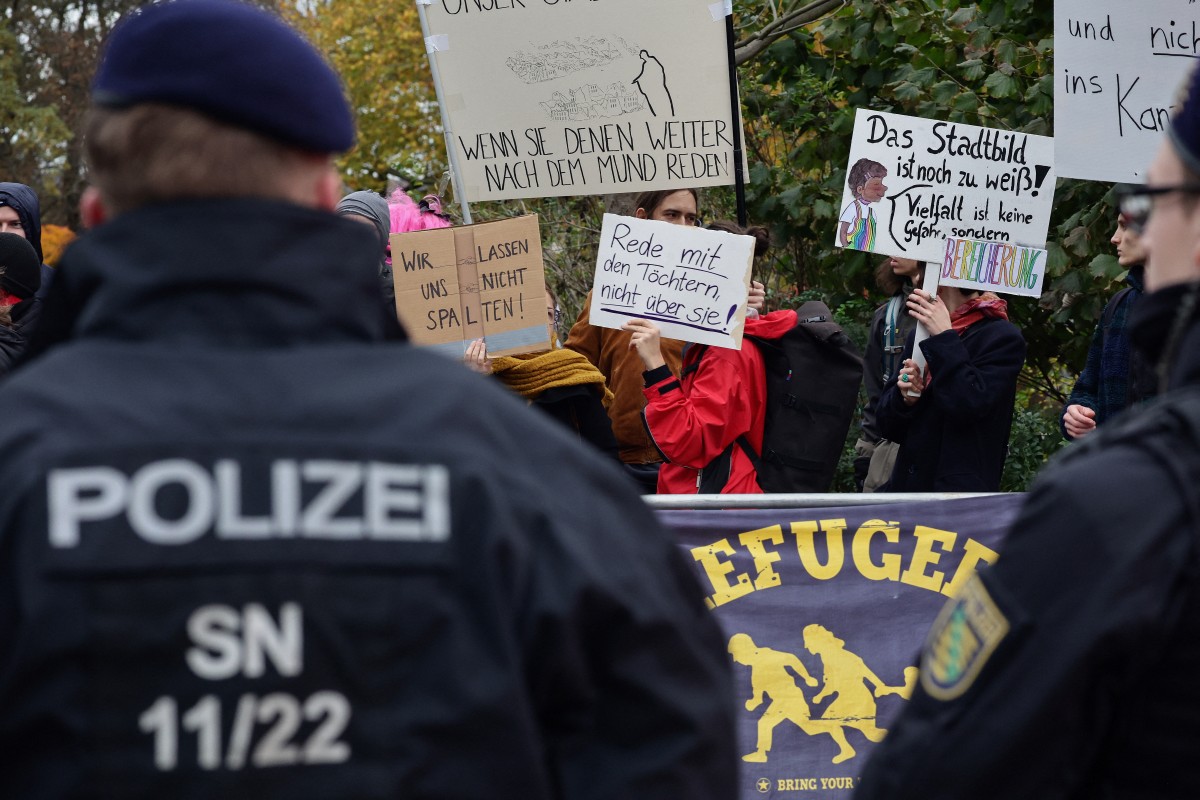 متظاهرون يحتجون على زيارة ميرتس ميرز إلى دريسدن شرقي ألمانيا. (أ ف ب)