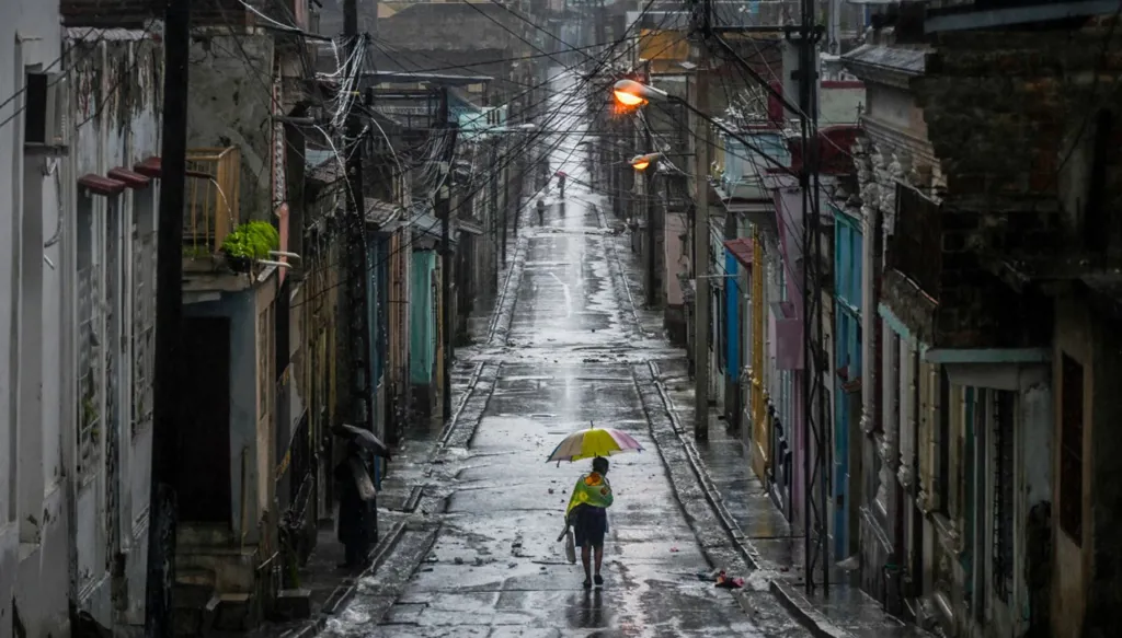 امرأة تسير في شارع قبل أن يضرب إعصار ميليسا مدينة سانتياغو دي كوبا (أ ف ب)