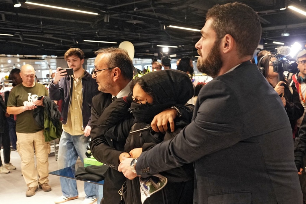 امرأة يتم إجلاؤها من قبل أفراد من جهاز الأمن (أ ف ب)