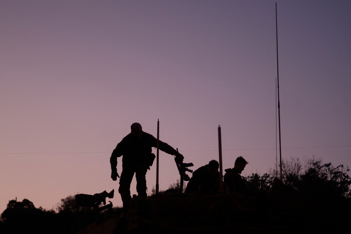 جنود إسرائيليون يقفون على دبابة ميركافا في موقع شمال إسرائيل على طول الحدود مع جنوب لبنان. (ا ف ب)