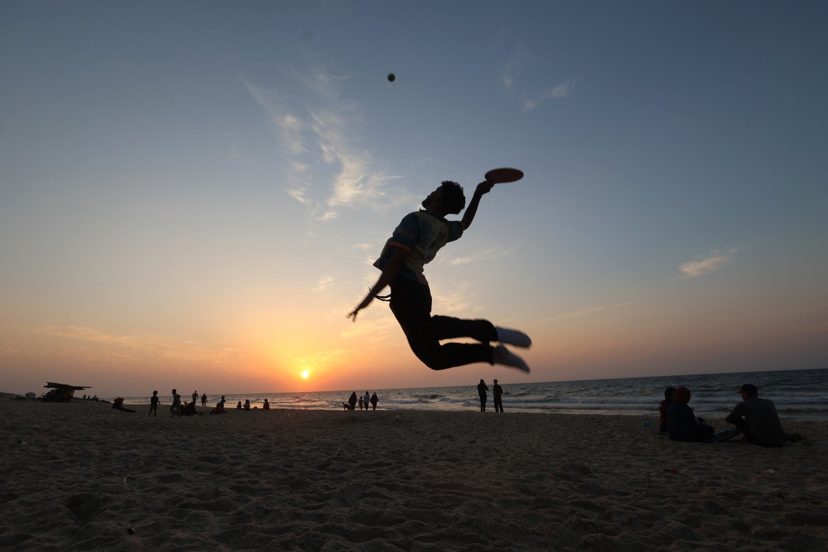 فلسطيني نازح يلعب كرة المضرب على الشاطئ مقابل مخيّم النصيرات وسط قطاع غزة. (أ ف ب)