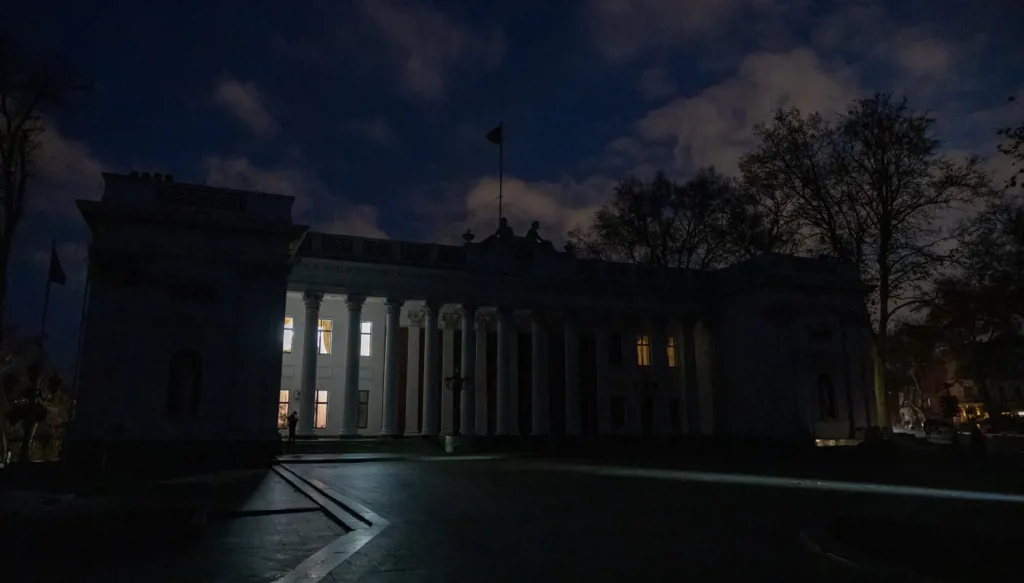 شخص يقف خارج مبنى مجلس المدينة خلال ساعات انقطاع التيار الكهربائي في مدينة أوديسا الجنوبية(أ ف ب)