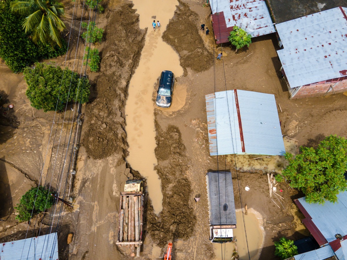 تظهر هذه الصورة الجوية شاحنة وسيارة محاصرتين في طين ناجم عن فيضانات مفاجئة على طريق رئيسي يربط بين آتشيه وشمال سومطرة في ميوريدو، منطقة بيدي جايا، مقاطعة آتشيه الإندونيسية. (أ ف ب)