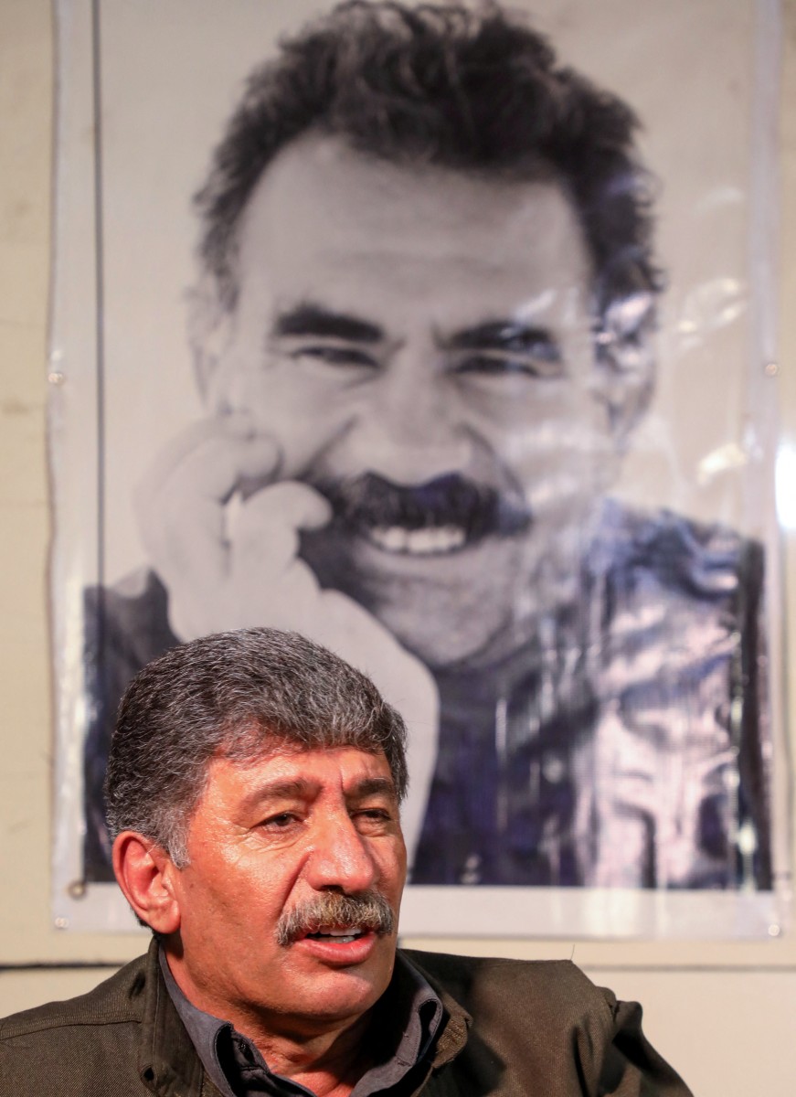 مقاتل وخلفه صورة أوجلان (أ ف ب)