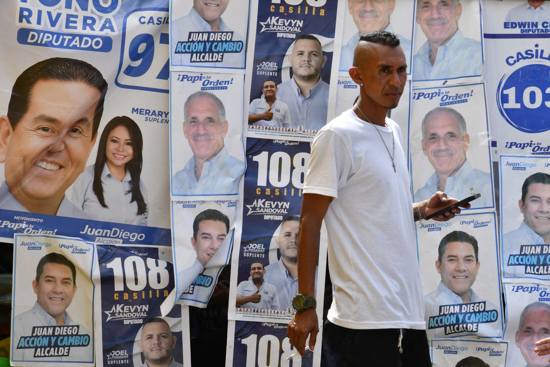 رجل يمر أمام دعاية انتخابية خلال الانتخابات العامة في هندوراس (أ ف ب).