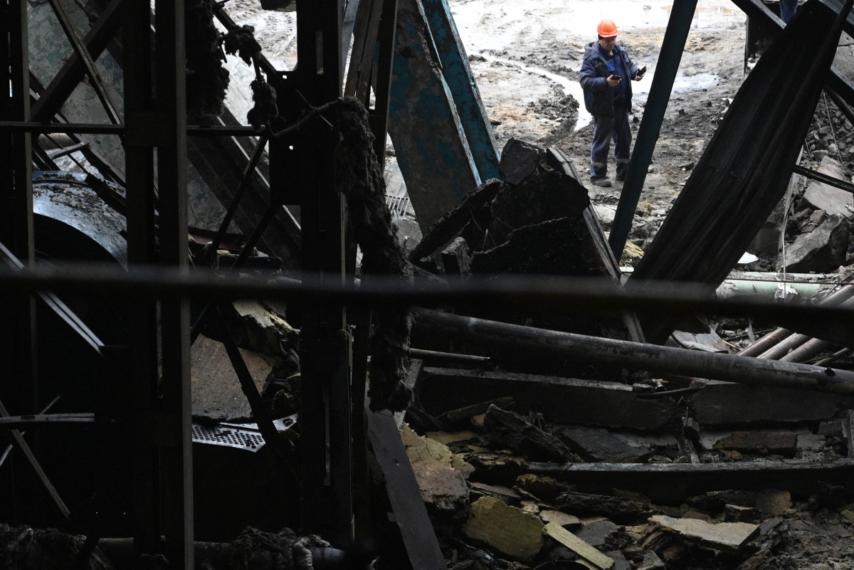 موظف يقف بجوار مبنى محطة توليد كهرباء تابعة لشركة الطاقة الأوكرانية DTEK، التي تعرضت لأضرار جسيمة خلال الغارات الجوية. (أ ف ب)