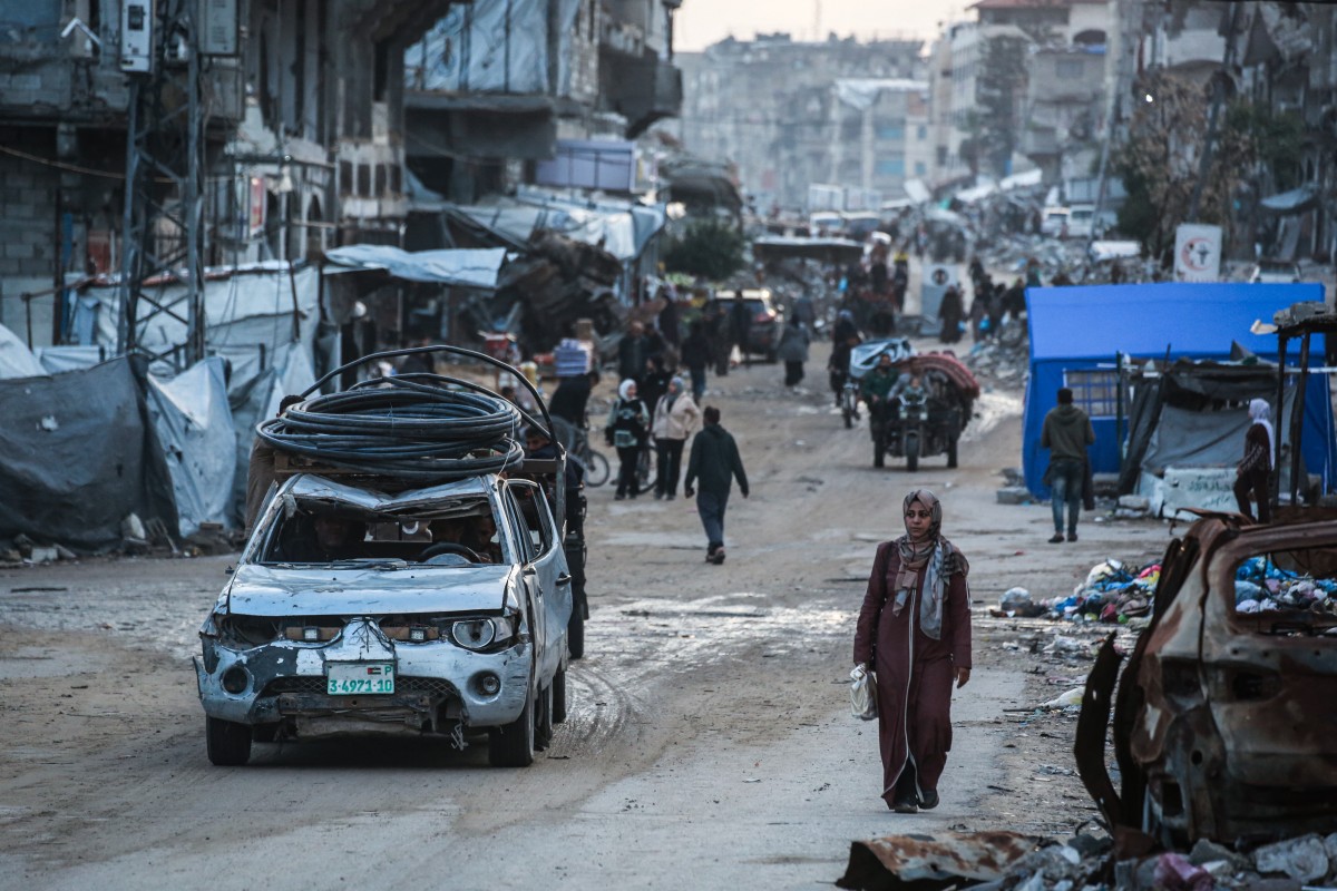 امرأة تسير في طريق بحي الصفتاوي، غرب مدينة جباليا في شمال قطاع غزة. (أ ف ب)