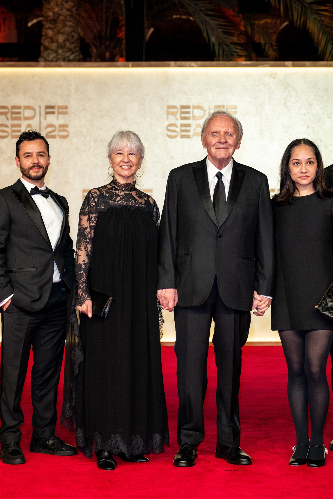 السير أنتوني هوبكنز وعائلته يسيرون على السجادة الحمراء أثناء حضورهم حفل اختتام النسخة الخامسة من مهرجان البحر الأحمر السينمائي في جدة (أ ف ب).