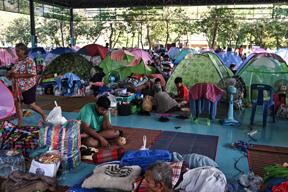 السكان النازحون يستريحون في مركز إجلاء في مقاطعة سورين الحدودية التايلاندية. (أ ف ب)