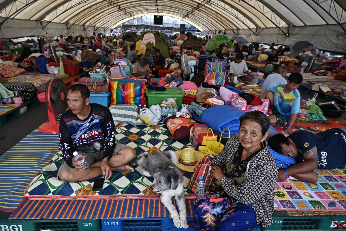السكان النازحون يستريحون في مركز إجلاء في حلبة تشانغ الدولية في مقاطعة بوريرام الحدودية التايلاندية. (أ ف ب)