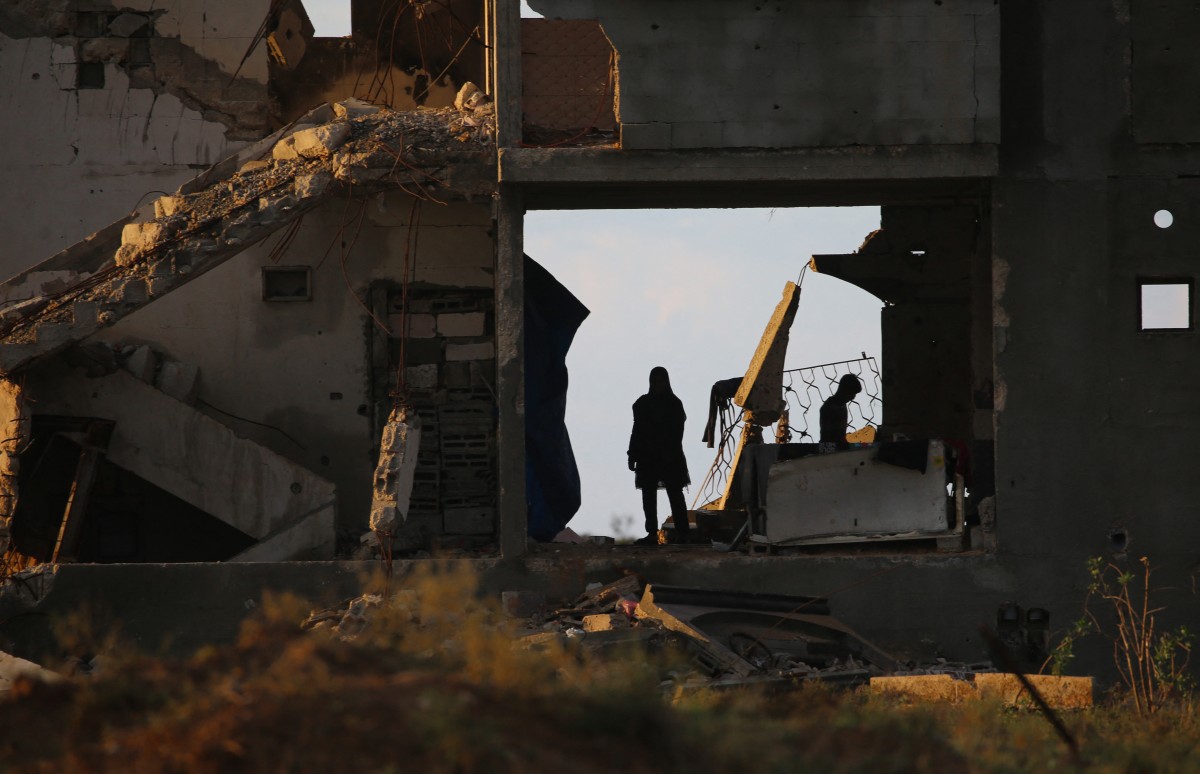 لاجئون فلسطينيون فقدوا منازلهم في حرب غزة يلجأون إلى بقايا مبنى بعد هطول أمطار غزيرة في مخيم النصيرات. (أ ف ب)