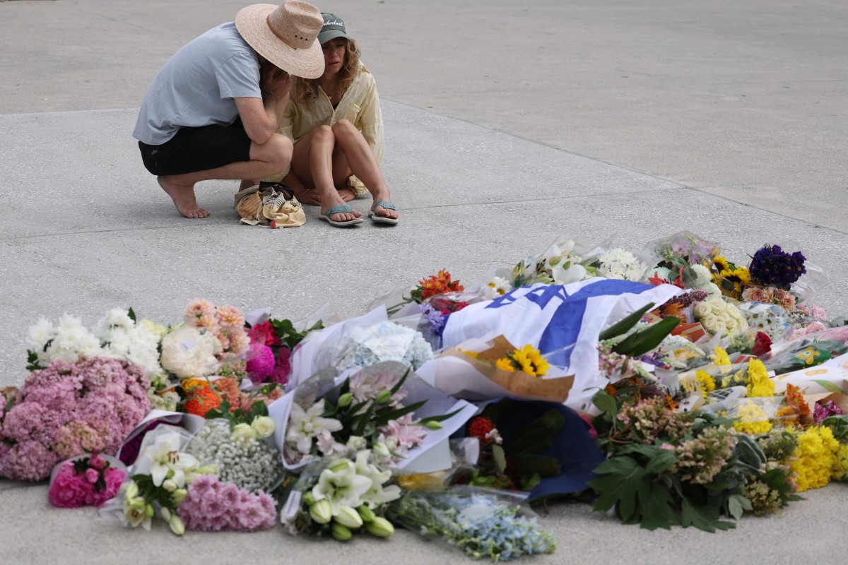 وُضعت باقات من الورود وعلم إسرائيل في المكان الذي نُفذ فيه هجوم سيدني. (أ ف ب)