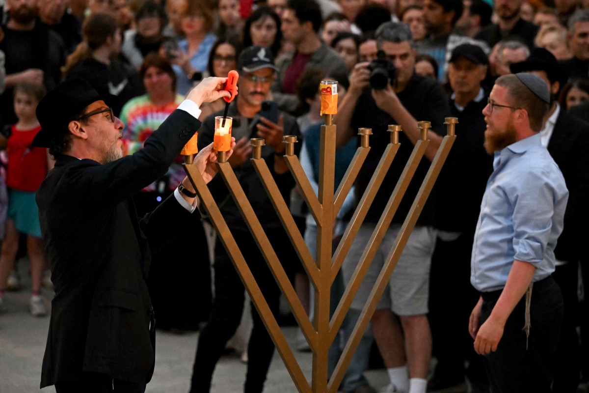 إضاءة شموع بعد حادث سيدني (أ ف ب).