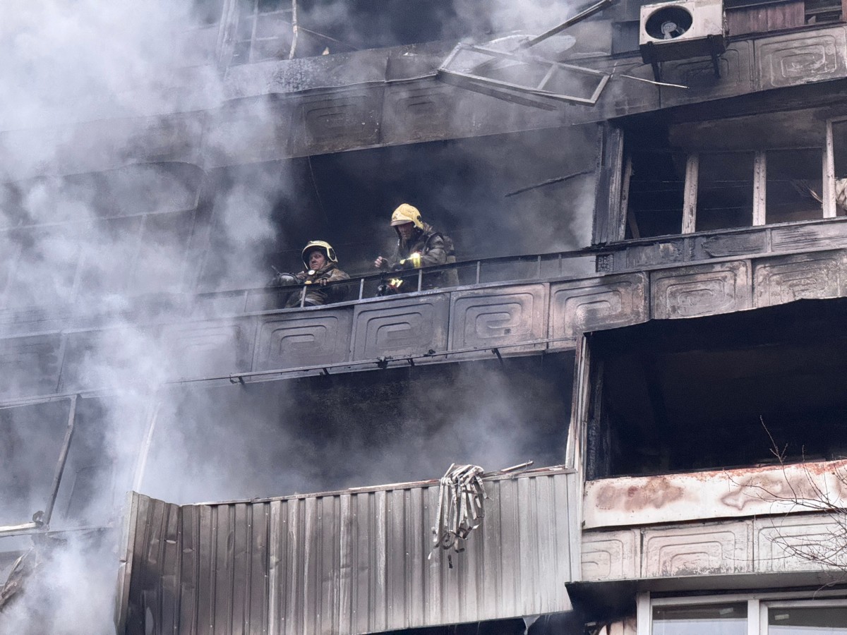 يقف رجال الإطفاء على شرفة مبنى سكني متضرر في أعقاب غارة جوية في أوكرانيا. (أ ف ب)