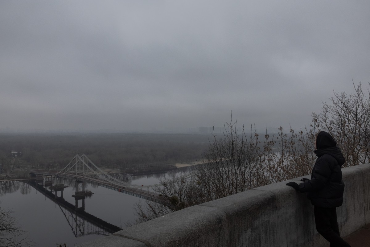 سيدة تقف عند نهر دنيبرو وتنظر الى العاصمة الاوكرانية (أ ‏ف ب)‏