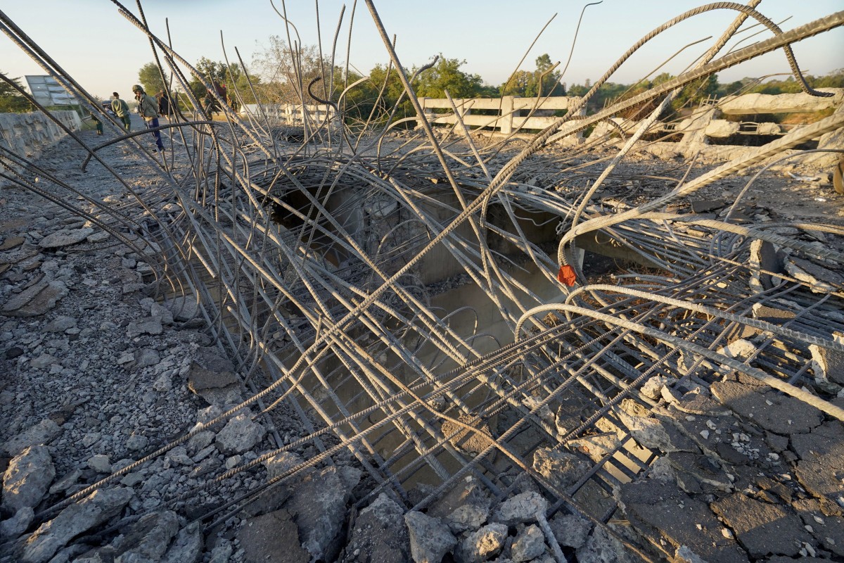 رجل ينظر إلى جسر متضرر بعد أن شنت تايلاند غارات جوية في منطقة تقع بين مقاطعتي أودار مينشي وسييم ريب في كمبوديا في 20 ديسمبر 2025. (أ ف ب)