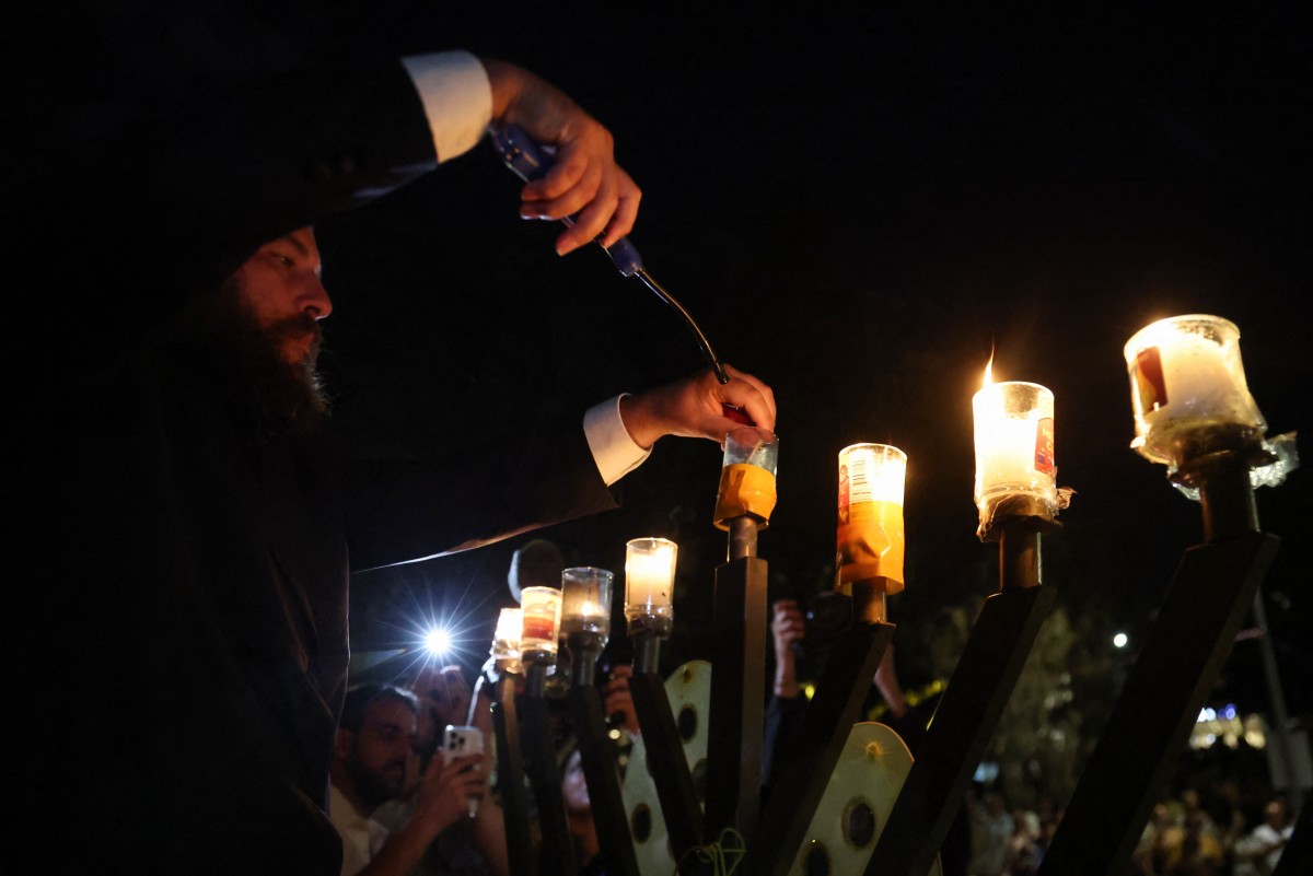 يتجمع المشيعون بجانب الزهور الموضوعة تكريماً لضحايا حادث إطلاق النار في شاطئ بوندي، في سيدني في 20 ديسمبر 2025. (أ ف ب)