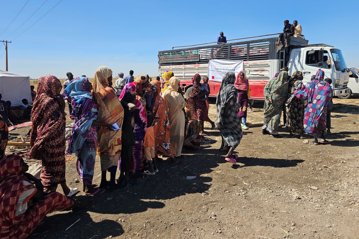 لاجئات سودانيات ينتظرون دورهن للحصول على وجبة غذائية في القضارف.(أف ب)