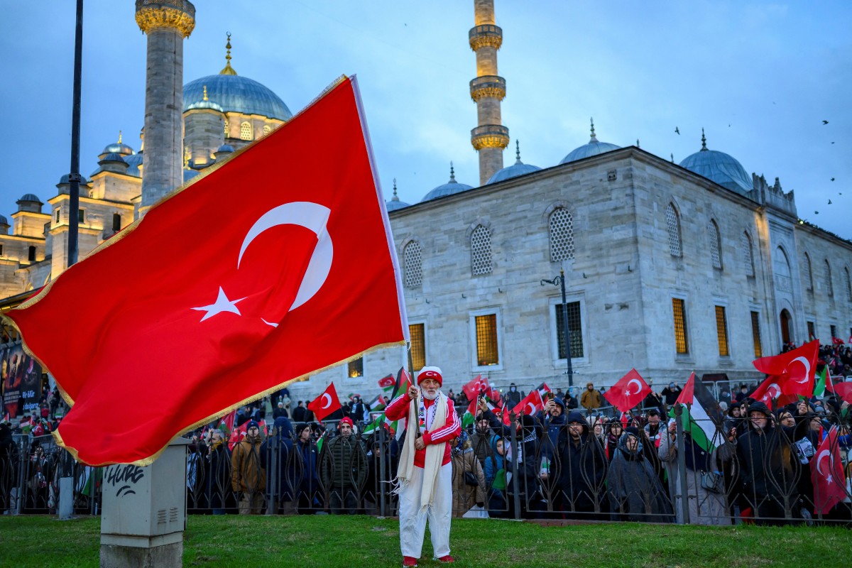 رفع الناس الأعلام التركية والفلسطينية أثناء مظاهرتهم تضامناً مع الشعب الفلسطيني وسط الحرب الدائرة بين إسرائيل وحركة حماس الفلسطينية في قطاع غزة، عند جسر غلطة في إسطنبول في 1 كانون الأول/يناير 2026. (أ ف ب)