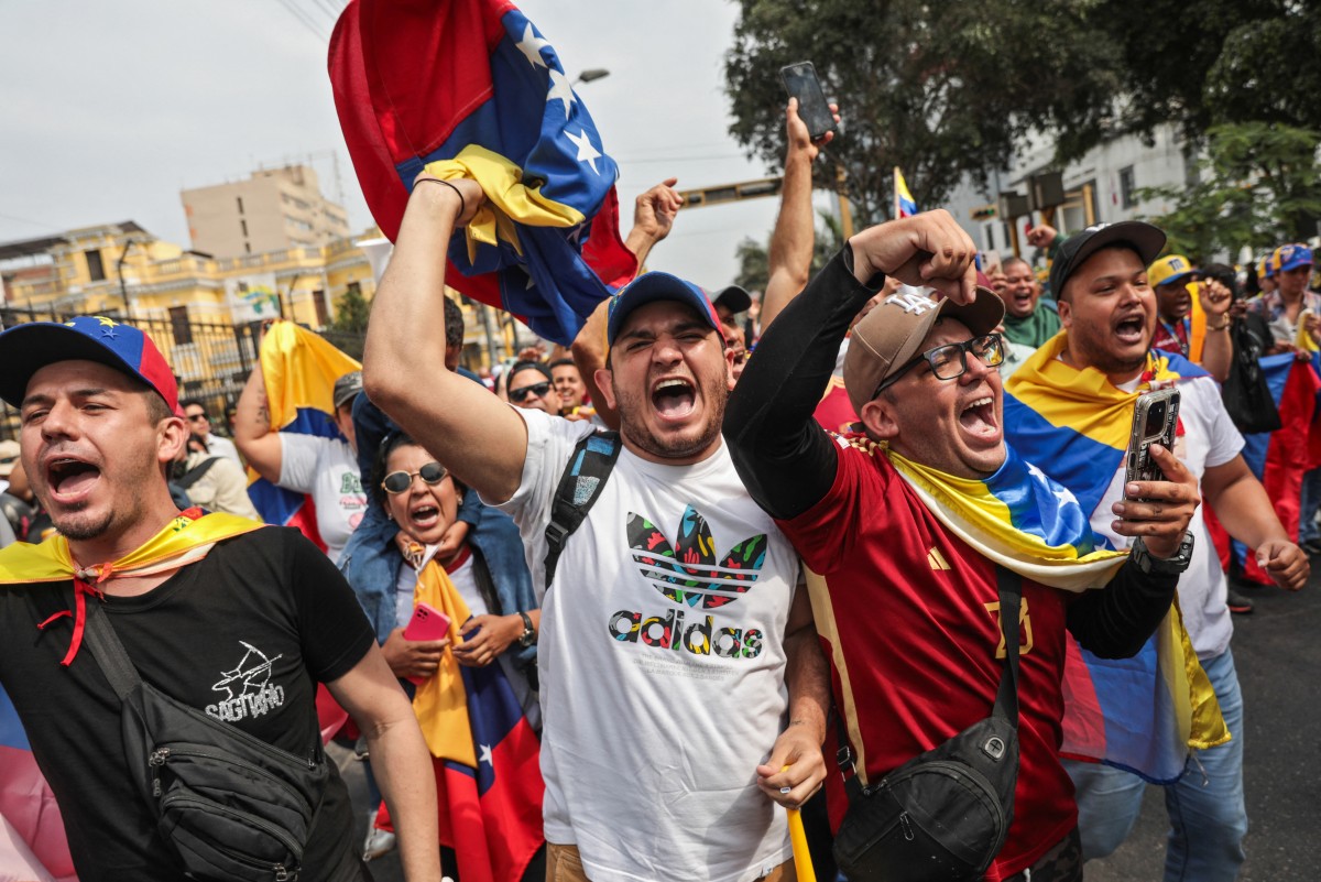 الفنزويليون المقيمون في بيرو يحتفلون أمام السفارة الفنزويلية في ليما في 3 يناير 2026 (أ ف ب)