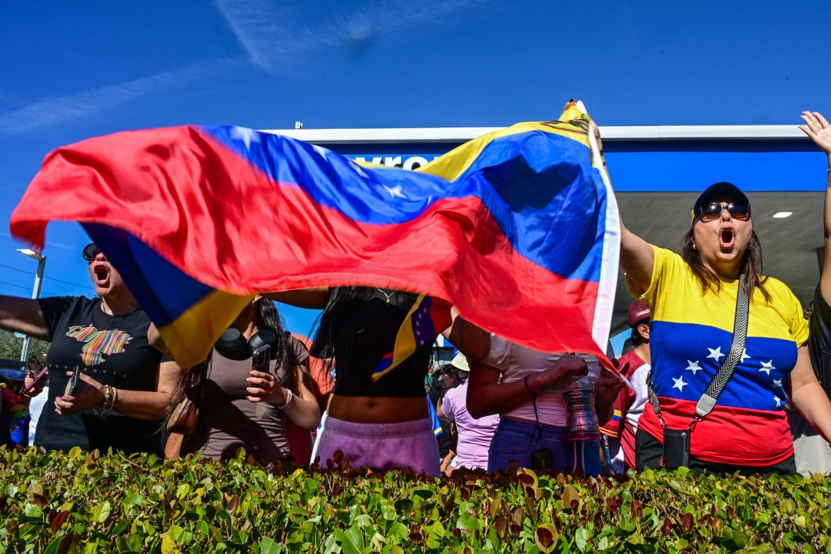 فنزويليون يحملون العلم. (أ ف ب)