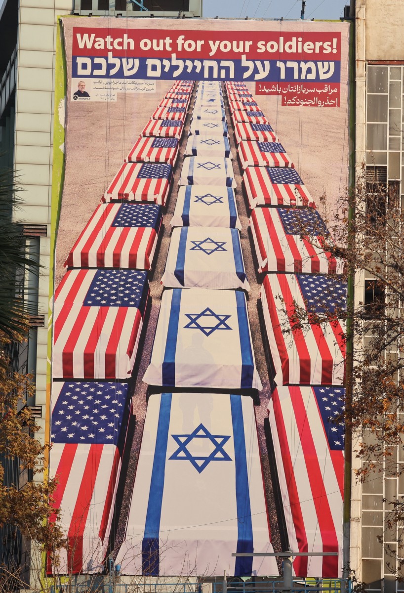 لوحة إعلانية معادية للولايات المتحدة وإسرائيل تحمل رسالة من أمين المجلس الأعلى للأمن القومي تقول 