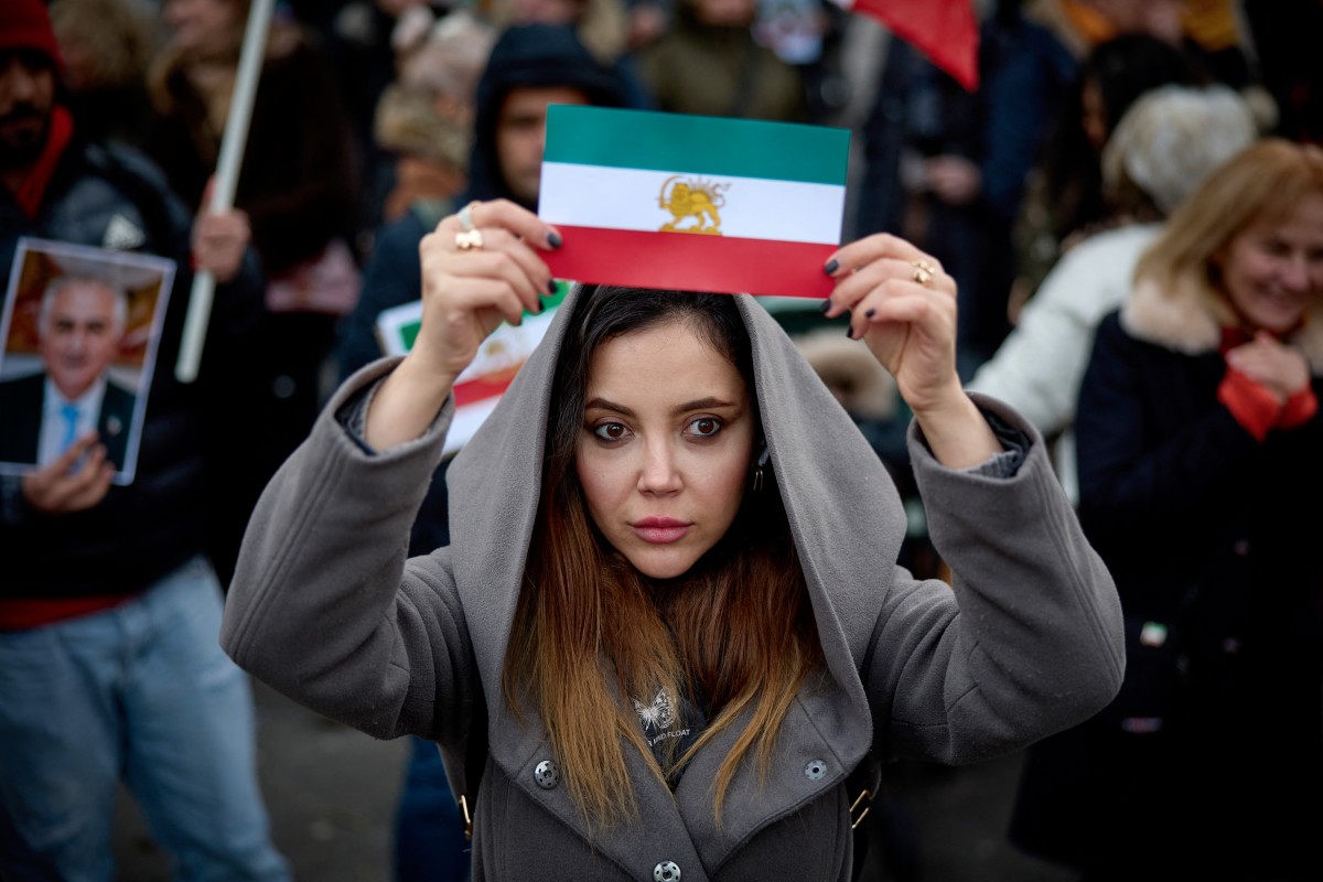 متظاهرة في باريس ترفع علم إيران قبل الثورة الإسلامية عام 1979 (أ ف ب)