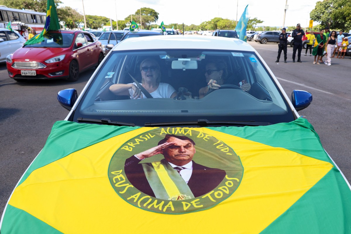 صورة بولسونارو عى علم البرازيل. (أ ف ب)