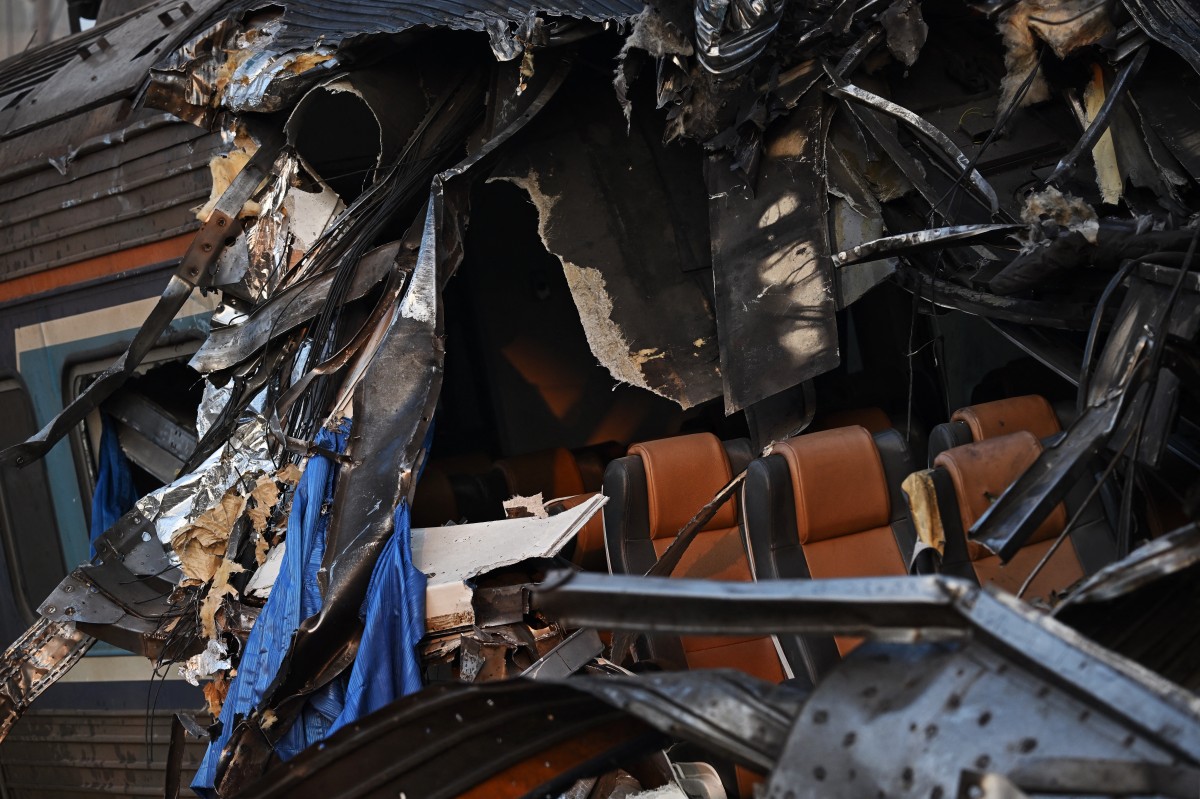  حطام قطار تحطم عند انهيار رافعة بناء في اليوم السابق. (أ ف ب)